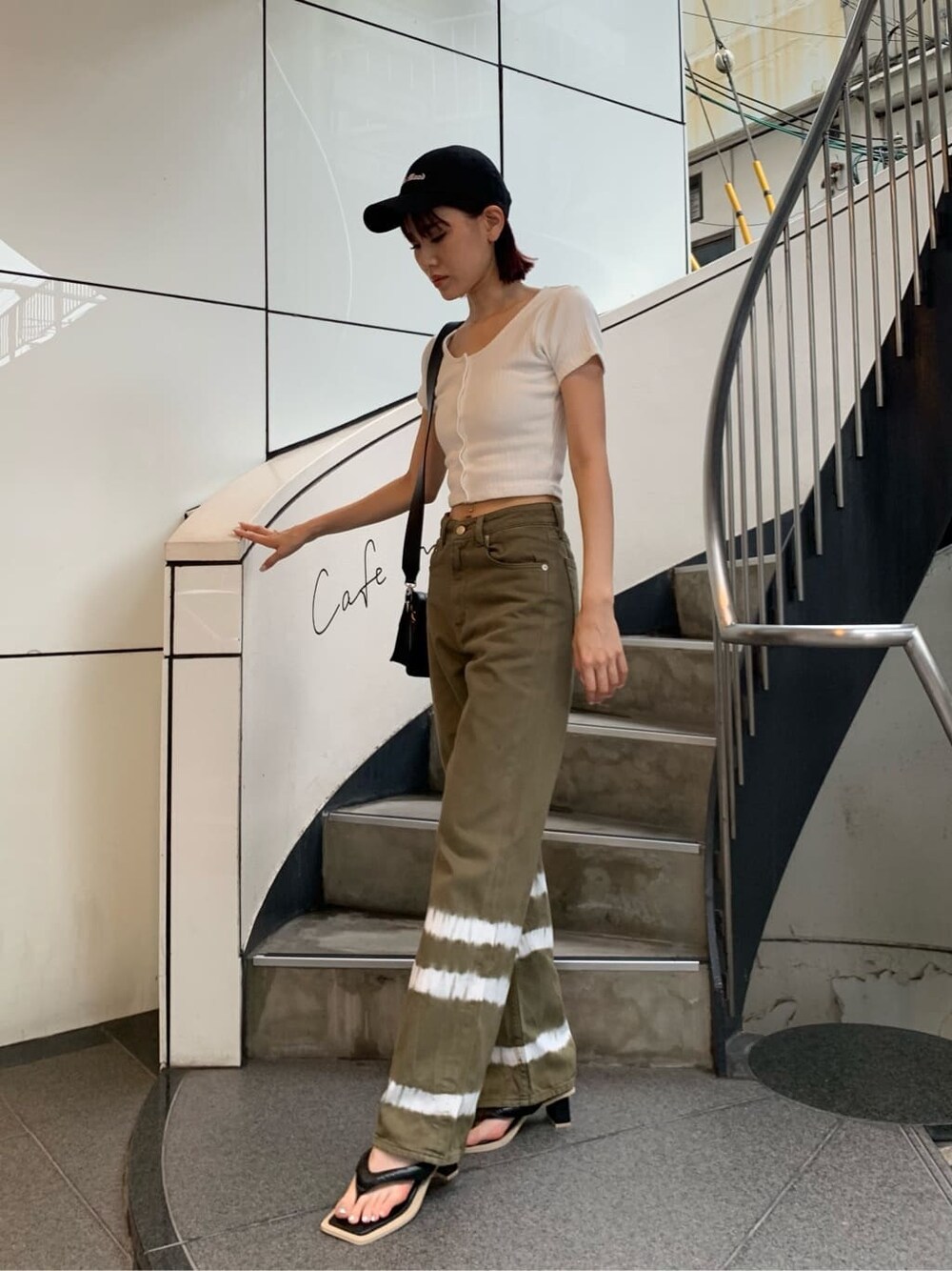 ホワイト系のTシャツ/カットソー、ブラック系のサンダル、ブラック系のショルダーバッグを着用したレディースの夏コーディネートの2枚目の写真