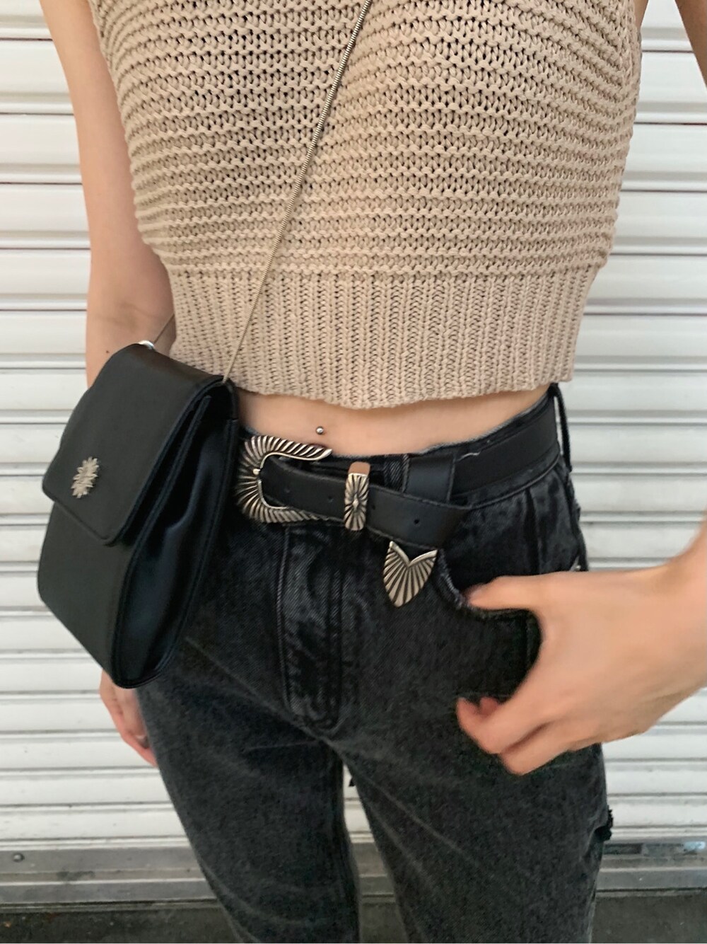 ブラック系のサンダル、ブラック系のデニムパンツ、ベージュ系のタンクトップを着用したレディースの春コーディネートの6枚目の写真