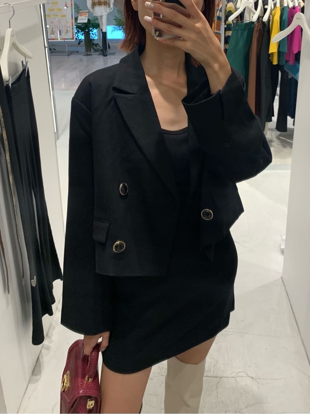 ブラック系のテーラードジャケット、ブラック系のスカート、ホワイト系のブーツを着用したレディースの秋コーディネートの3枚目の写真