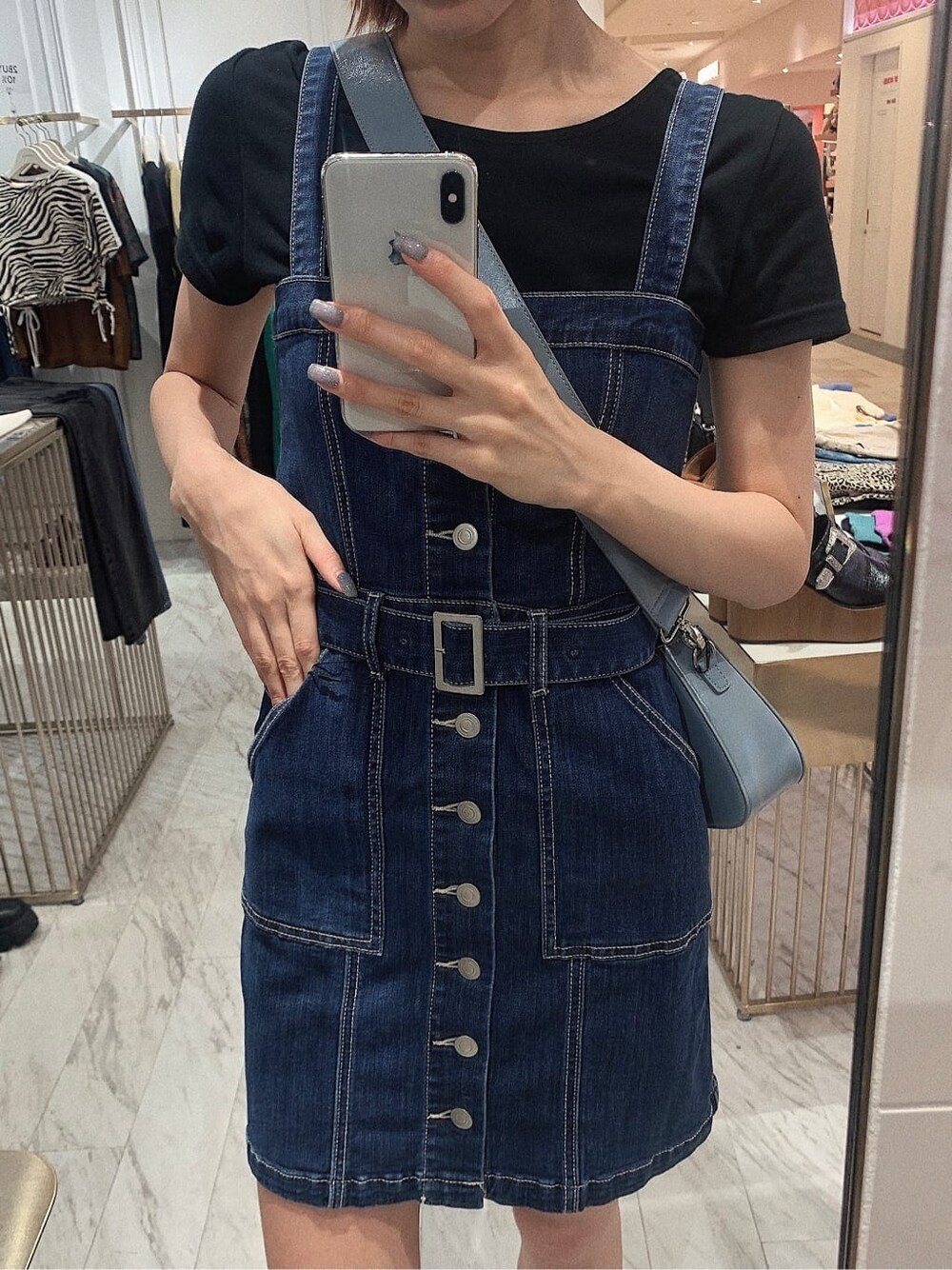 ブラック系のブーツ、ブラック系のTシャツ/カットソー、ブルー系のジャンパースカートを着用したレディースの春コーディネートの3枚目の写真