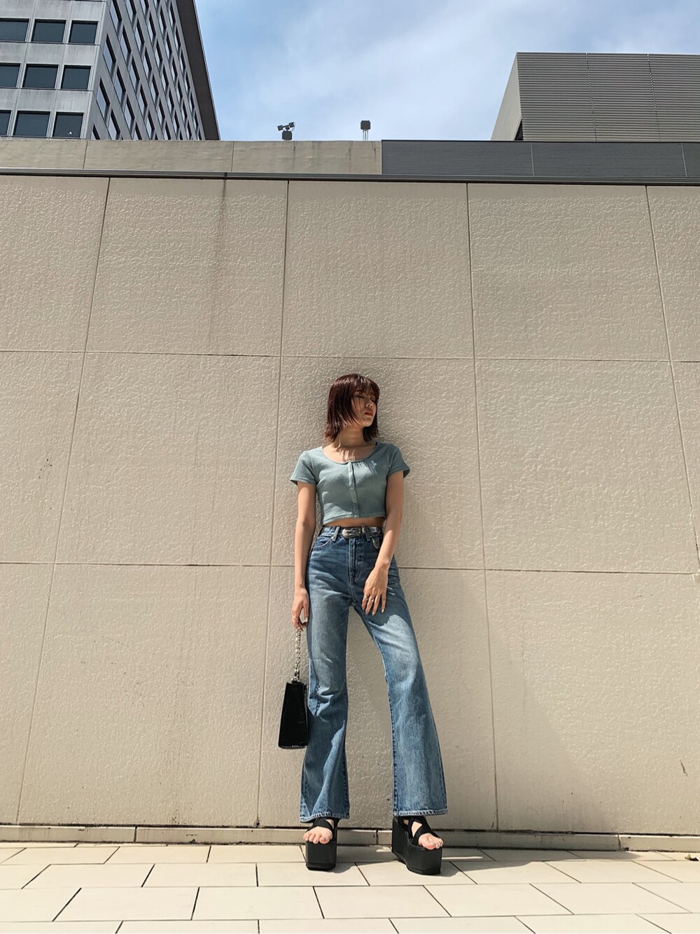 ブラック系のサンダル、ブルー系のデニムパンツ、その他のベルトを着用したレディースの春コーディネートの3枚目の写真