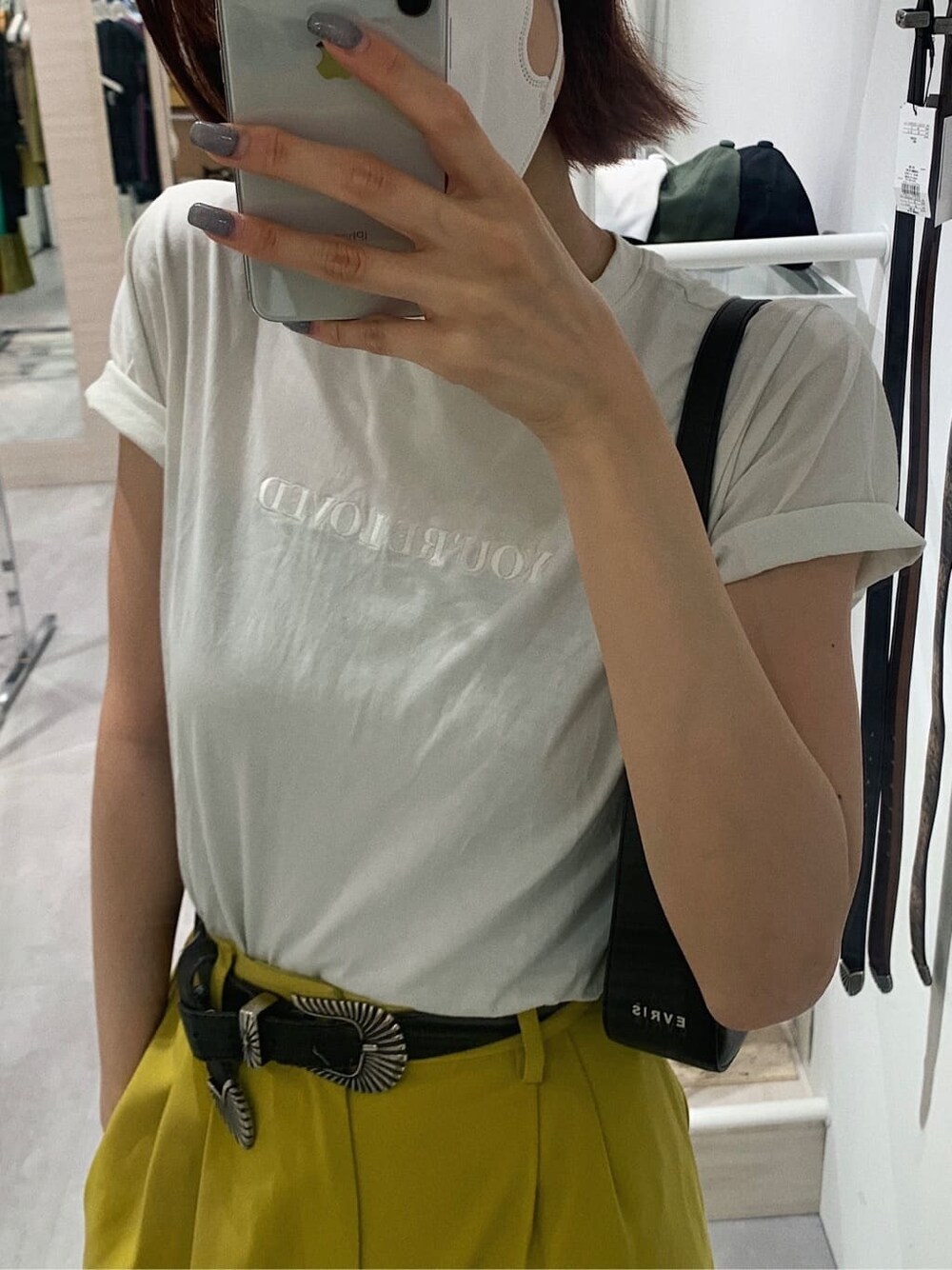 イエロー系のスラックス、ホワイト系のTシャツ/カットソー、ブラック系のブーツを着用したレディースの春コーディネートの3枚目の写真