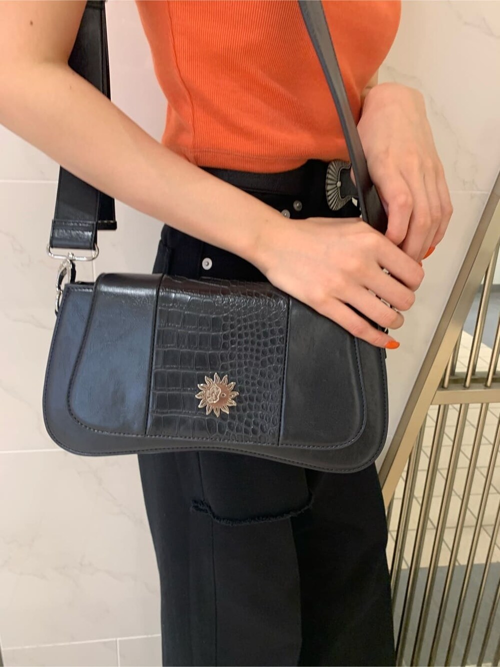 オレンジ系のTシャツ/カットソー、ブラック系のサンダル、ブラック系のショルダーバッグを着用したレディースの春コーディネートの8枚目の写真