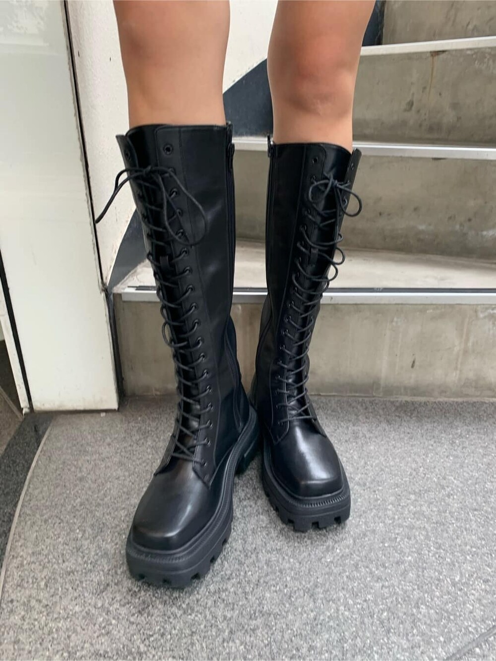 ブラック系のブーツ、ブルー系のハンドバッグ、グレー系のスウェットを着用したレディースの秋コーディネートの9枚目の写真