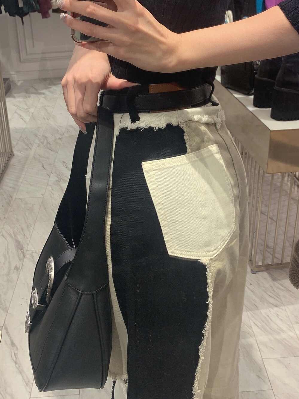 ブラック系のデニムパンツ、ブラック系のニット/セーター、ブラック系のブーツを着用したレディースの冬コーディネートの6枚目の写真