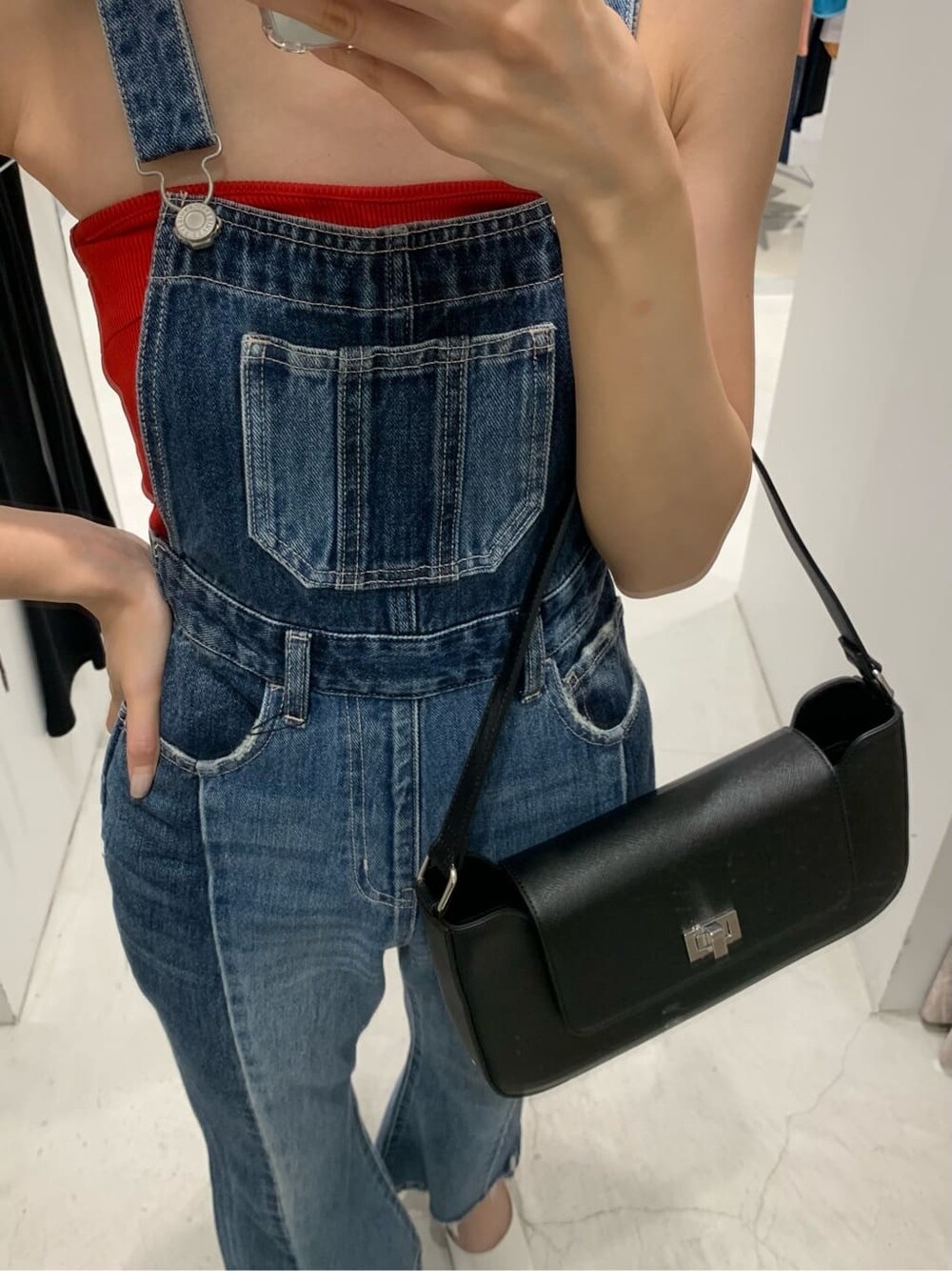 ブルー系のサロペット/オーバーオール、ブラック系のショルダーバッグ、ホワイト系のサンダルを着用したレディースの夏コーディネートの3枚目の写真