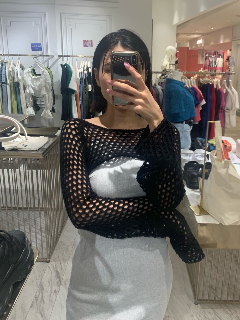 グレー系のワンピース、ブラック系のニット/セーター、ブラック系のブーツを着用したレディースの春コーディネートの3枚目の写真