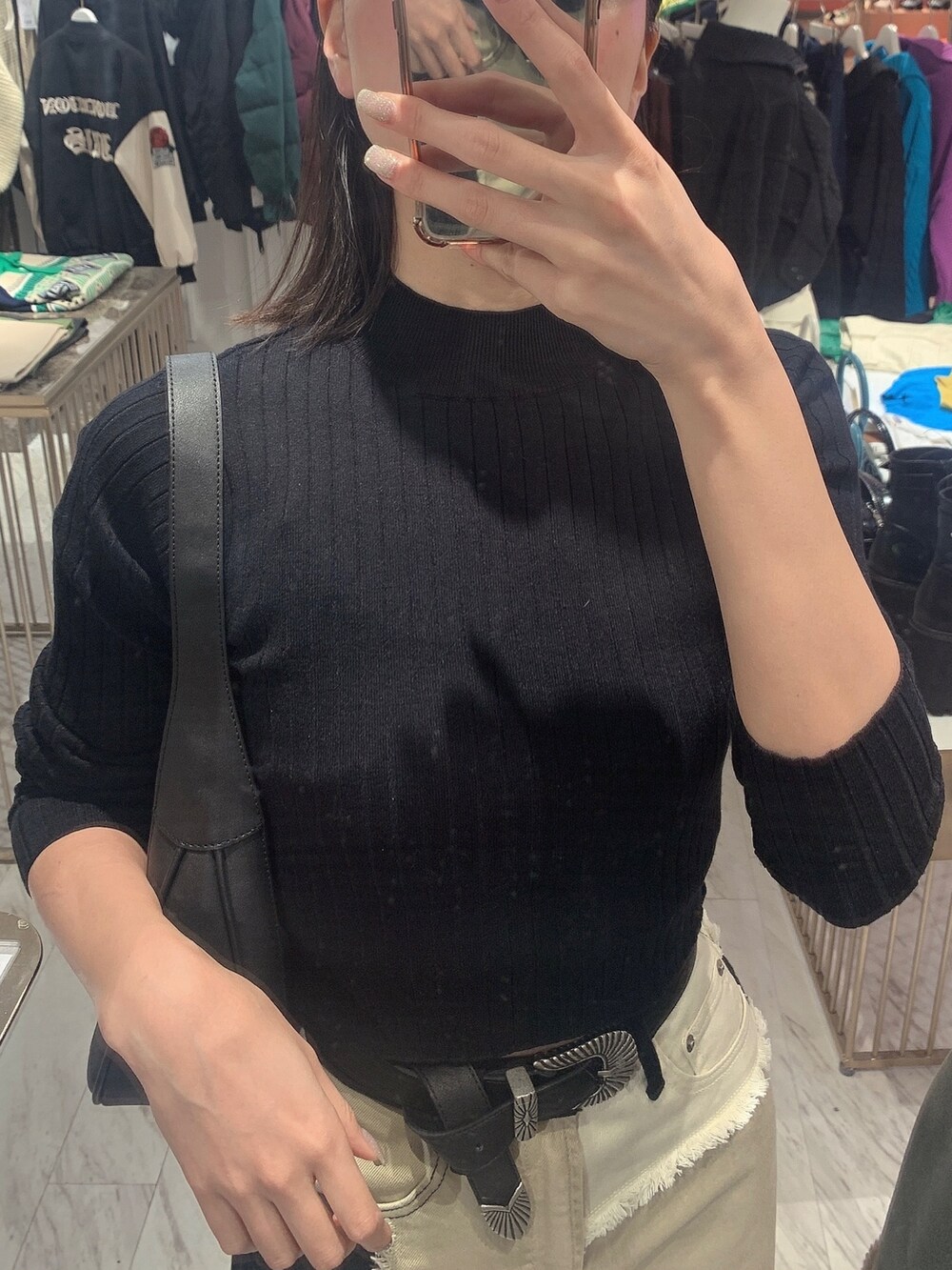 ブラック系のデニムパンツ、ブラック系のニット/セーター、ブラック系のブーツを着用したレディースの冬コーディネートの3枚目の写真