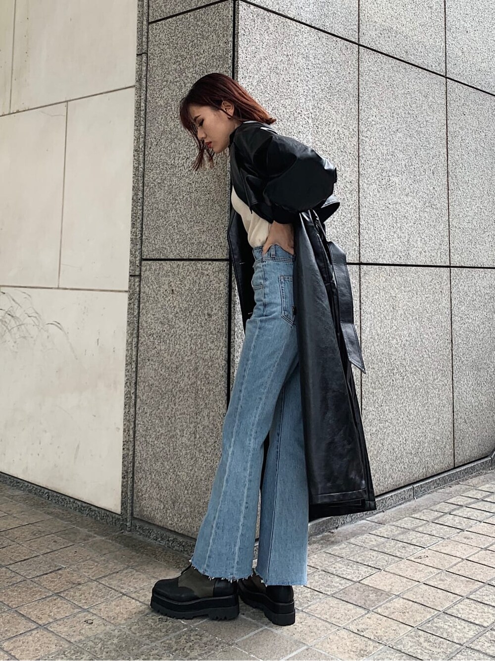 ホワイト系のニット/セーター、ベージュ系のブーツ、ブラック系のトレンチコートを着用したレディースの冬コーディネートの2枚目の写真