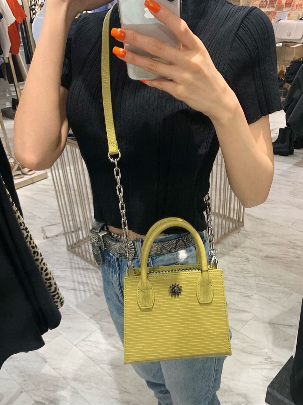 ブラック系のブーツ、ブラック系のニット/セーター、イエロー系のショルダーバッグを着用したレディースの春コーディネートの4枚目の写真