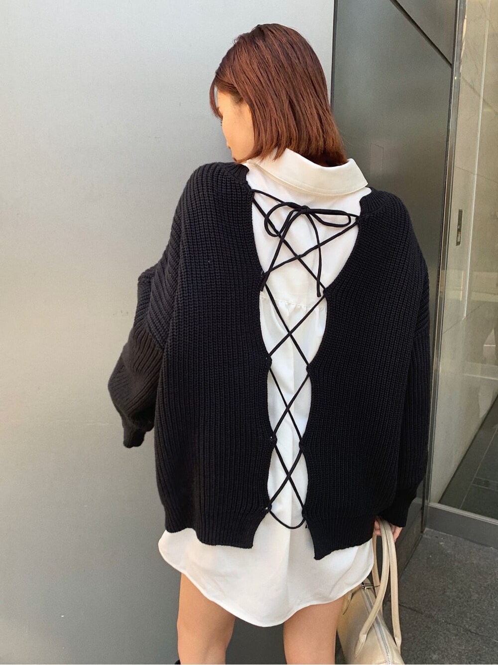 ブラック系のブーツ、ベージュ系のボストンバッグ、ホワイト系のシャツ/ブラウスを着用したレディースの冬コーディネートの5枚目の写真