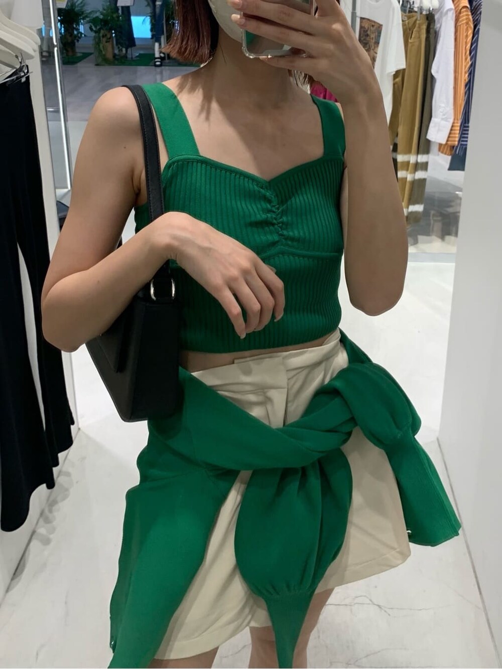 ホワイト系のその他パンツ、ブラック系のショルダーバッグ、グリーン系のカーディガン/ボレロを着用したレディースの夏コーディネートの2枚目の写真