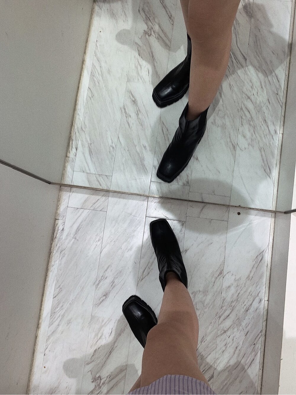 ホワイト系のスカート、ブラック系のブーツ、ホワイト系のショルダーバッグを着用したレディースの春コーディネートの9枚目の写真