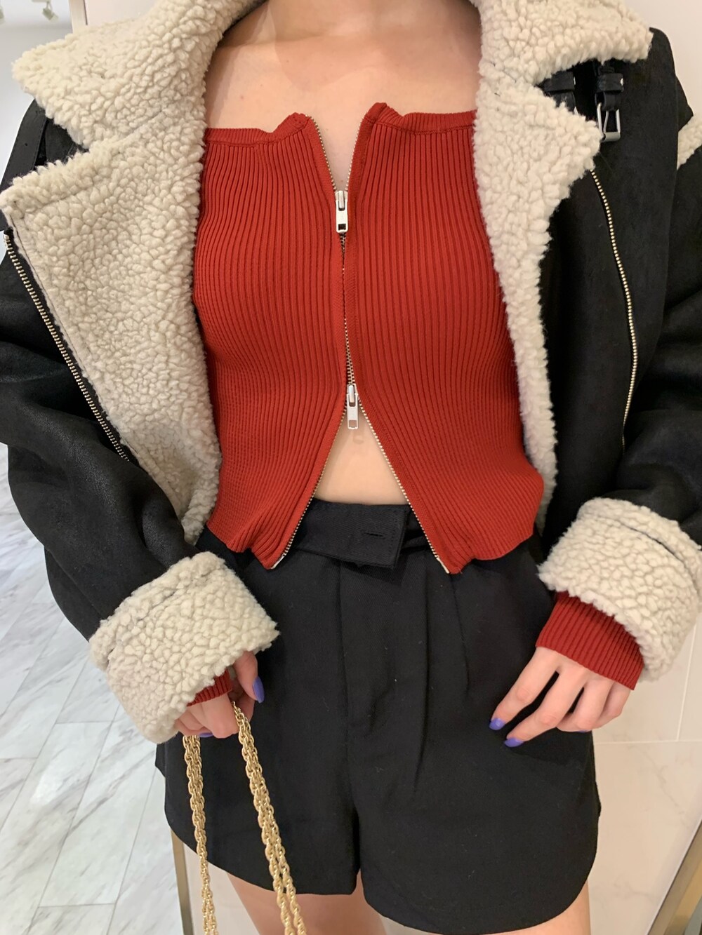 レッド系のニット/セーター、ブラック系のムートンコート、ブラック系のその他パンツを着用したレディースの夏コーディネートの4枚目の写真