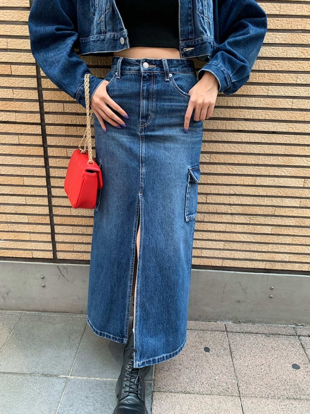 ブルー系のデニムジャケット、ブルー系のデニムスカート、レッド系のショルダーバッグを着用したレディースの秋コーディネートの5枚目の写真