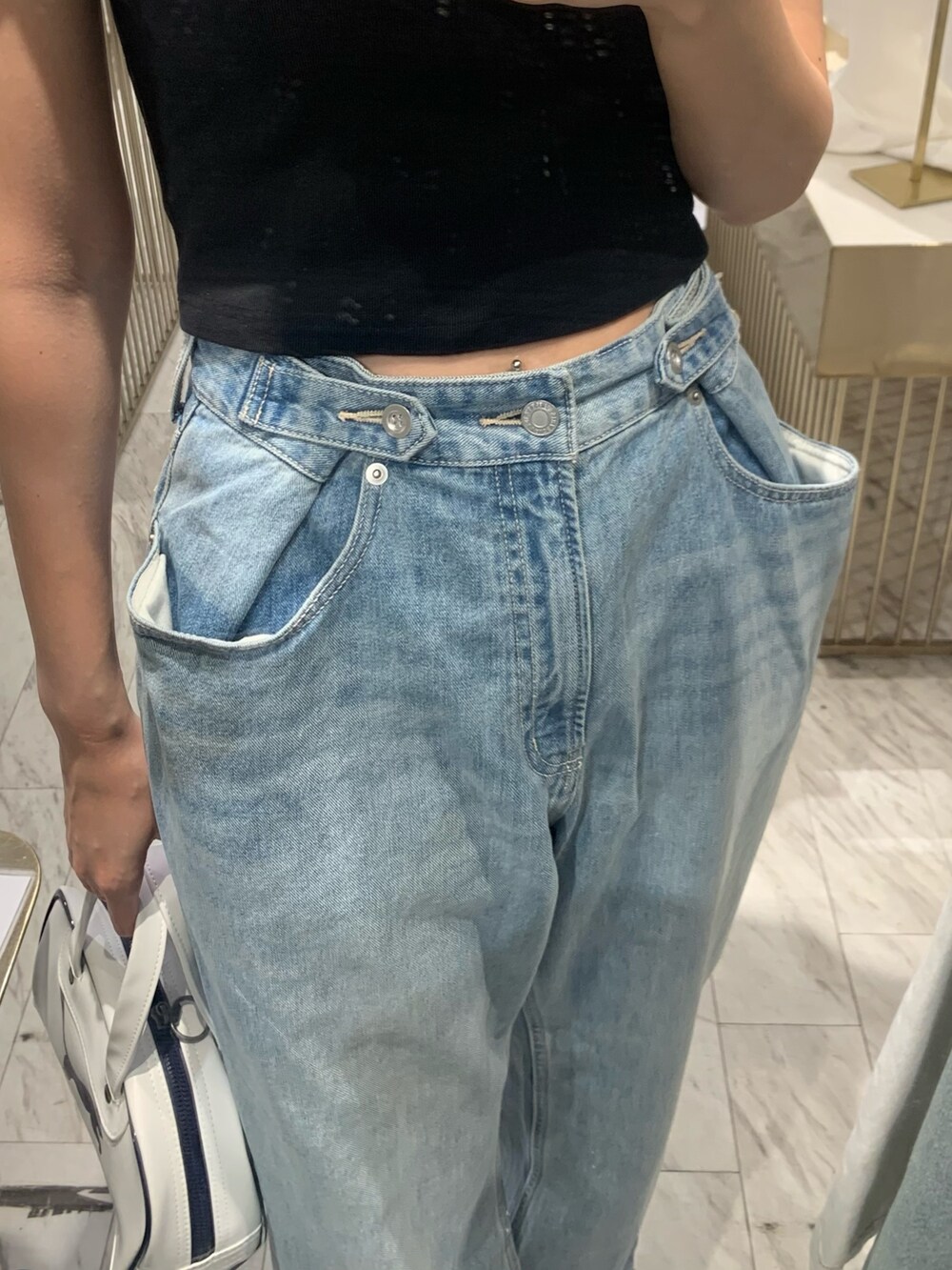 ブラック系のTシャツ/カットソー、ブルー系のデニムパンツ、ブラック系のブーツを着用したレディースの春コーディネートの6枚目の写真