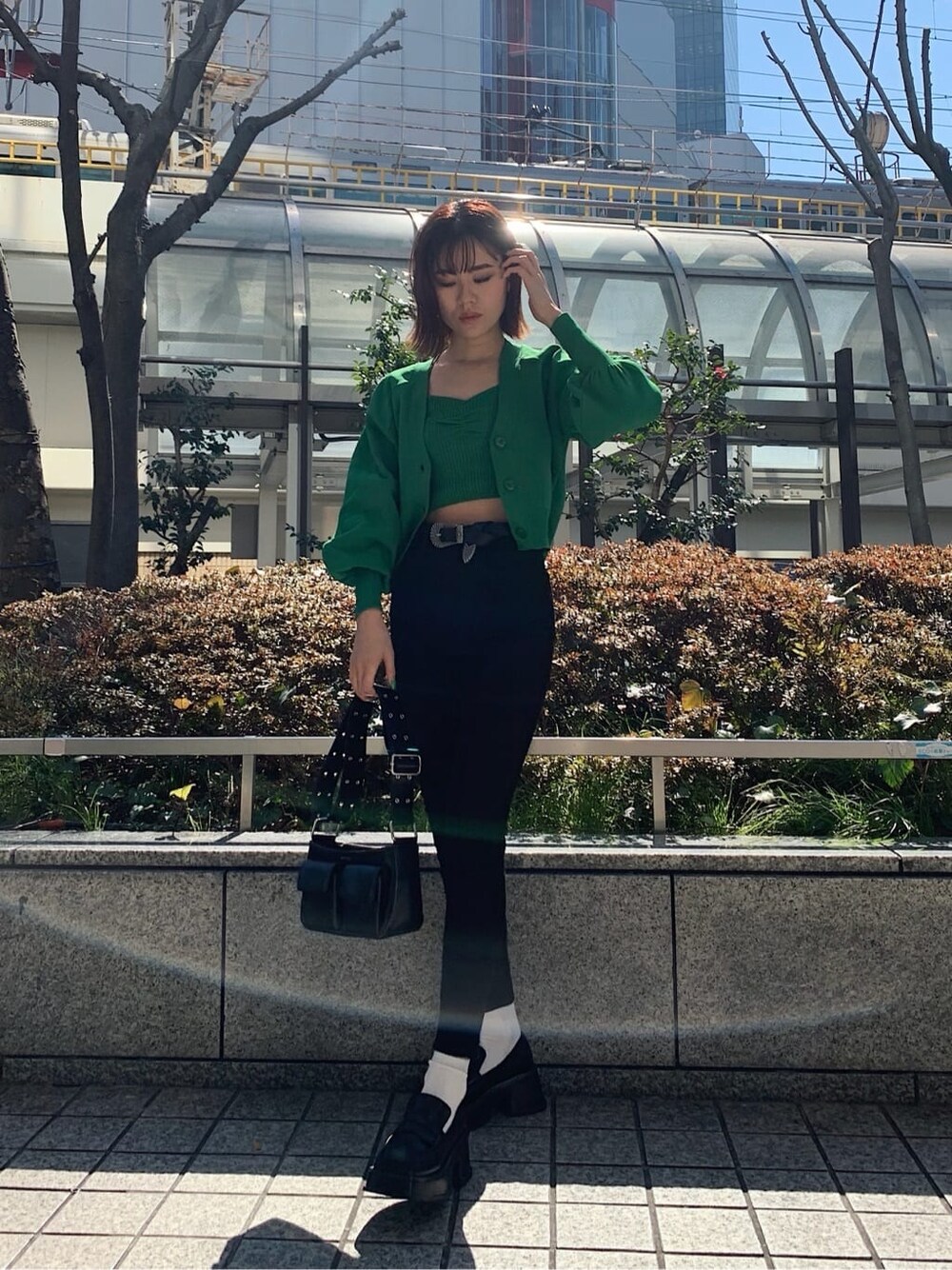 ブラック系のデニムパンツ、ブラック系のローファー、ブラック系のショルダーバッグを着用したレディースの春コーディネートの2枚目の写真