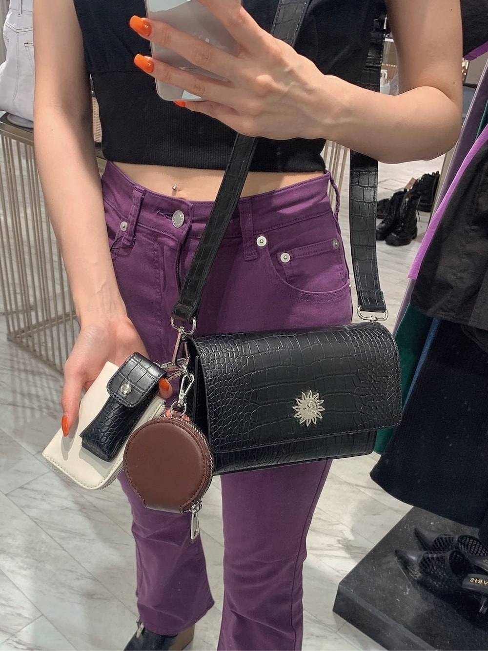 ブラック系のサンダル、パープル系のデニムパンツ、ブラック系のTシャツ/カットソーを着用したレディースの夏コーディネートの8枚目の写真