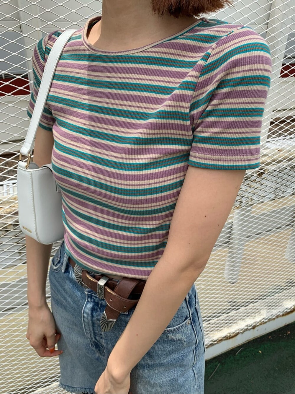 ブラウン系のサンダル、ブルー系のデニムパンツ、ホワイト系のショルダーバッグを着用したレディースの夏コーディネートの5枚目の写真