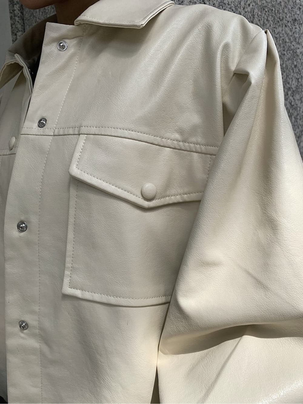 ホワイト系のテーラードジャケット、ブラック系のブーツ、ブラック系のショルダーバッグを着用したレディースの秋コーディネートの5枚目の写真