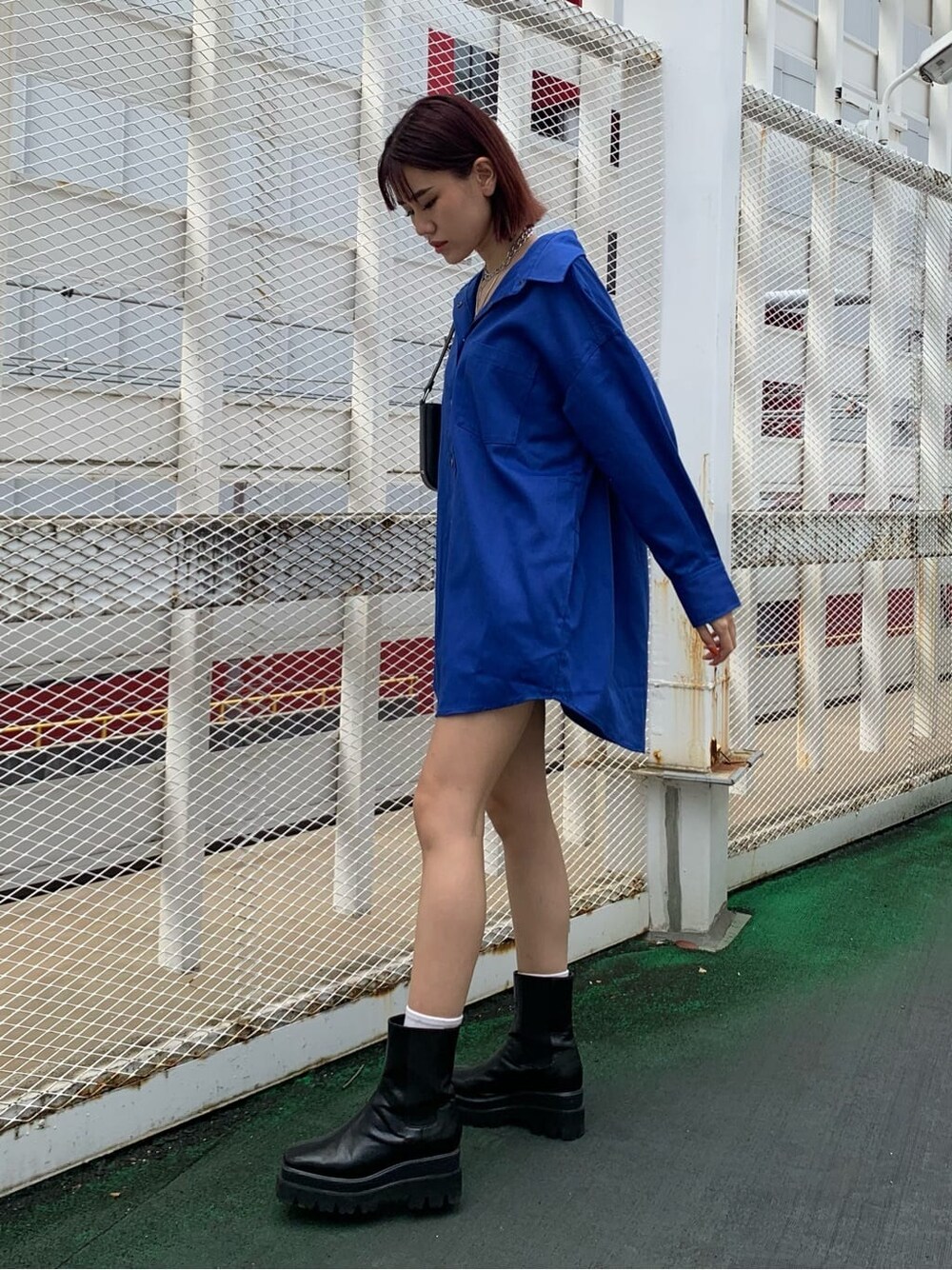 ブルー系のシャツ/ブラウス、ブラック系のブーツ、ブラック系のショルダーバッグを着用したレディースの夏コーディネートの2枚目の写真