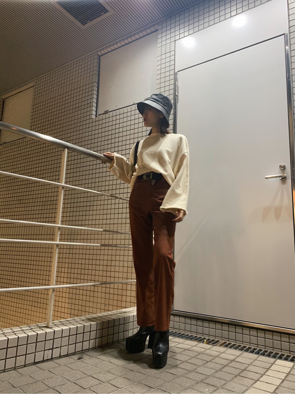 ホワイト系のスウェット、ブラック系のハット、ブラック系のベルトを着用したレディースの春コーディネートの3枚目の写真