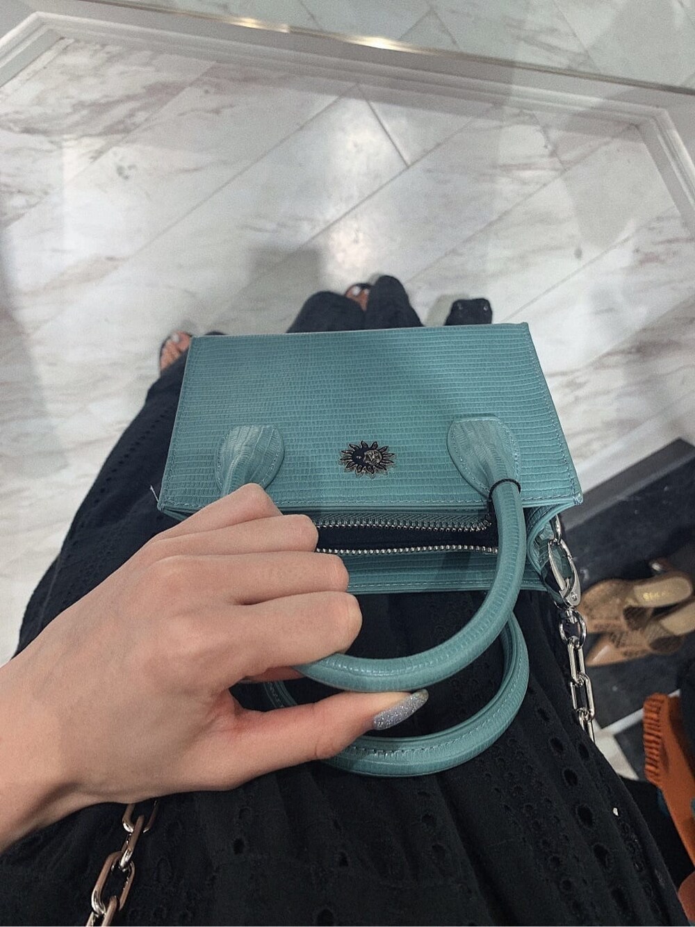 ブラック系のサンダル、ブラック系のワンピース、ブルー系のショルダーバッグを着用したレディースの春コーディネートの7枚目の写真