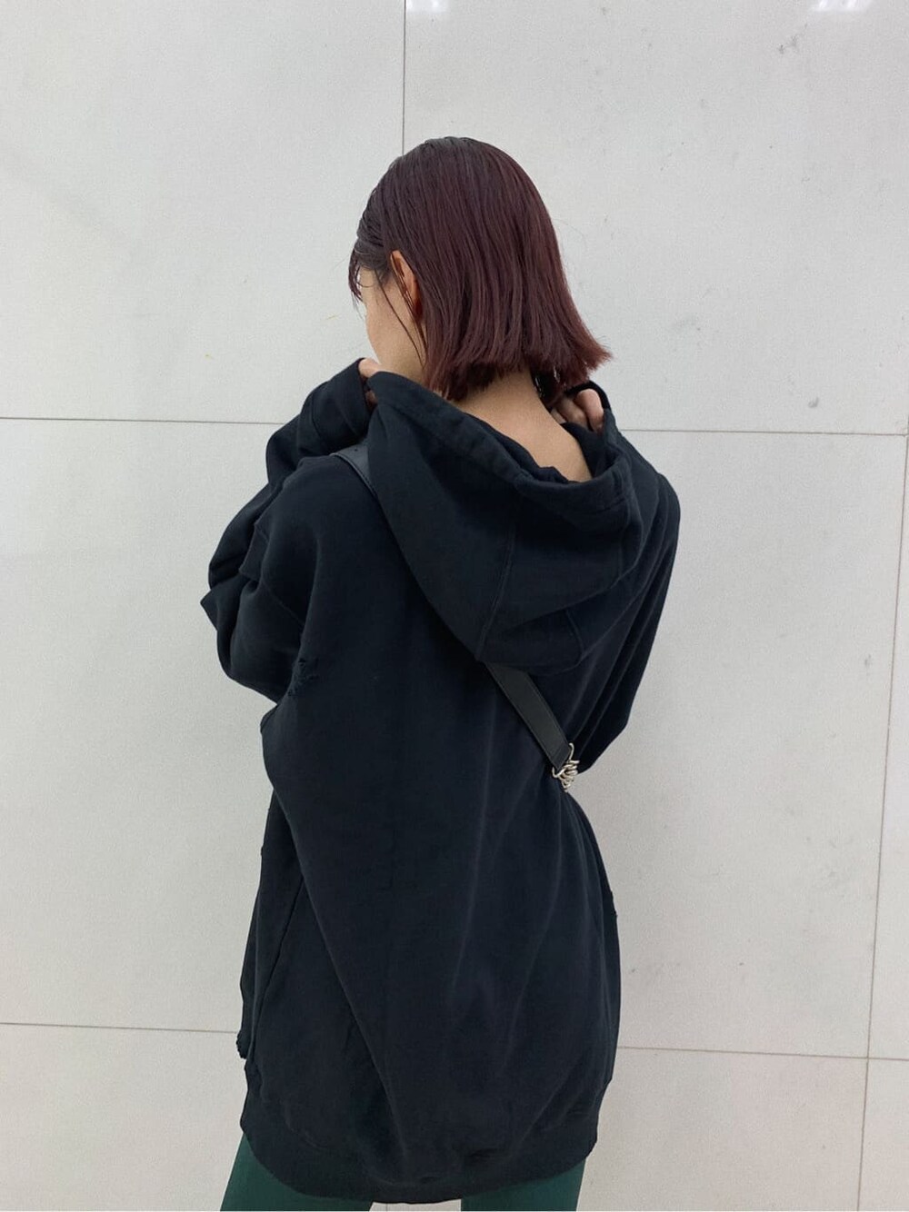 ブラック系のショルダーバッグ、ブラック系のブーツ、ブラック系のパーカーを着用したレディースの秋コーディネートの4枚目の写真