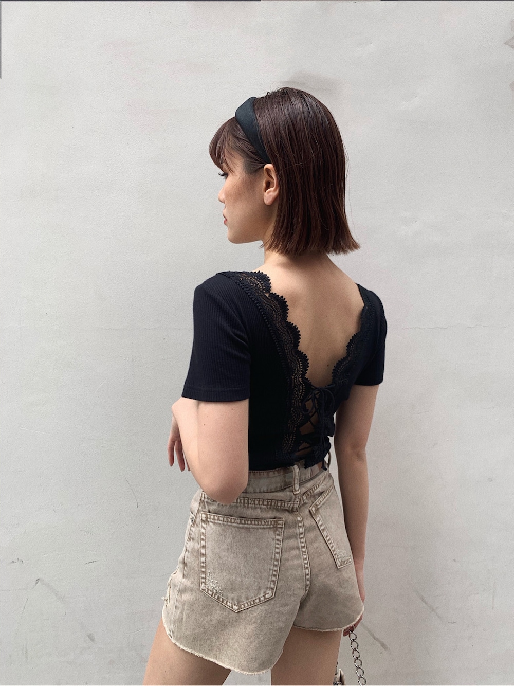 イエロー系のサンダル、ベージュ系のデニムパンツ、ブラック系のTシャツ/カットソーを着用したレディースの春コーディネートの6枚目の写真