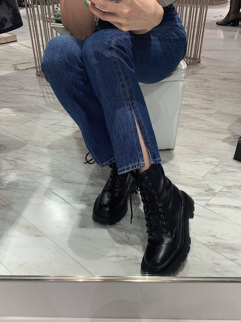 ホワイト系のニット/セーター、ブラック系のブーツ、ブルー系のデニムパンツを着用したレディースの冬コーディネートの4枚目の写真