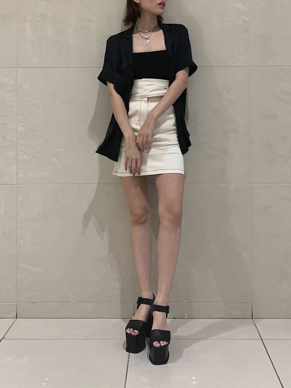 ホワイト系のスカート、ブラック系のサンダル、ブラック系のシャツ/ブラウスを着用したレディースの春コーディネートの3枚目の写真
