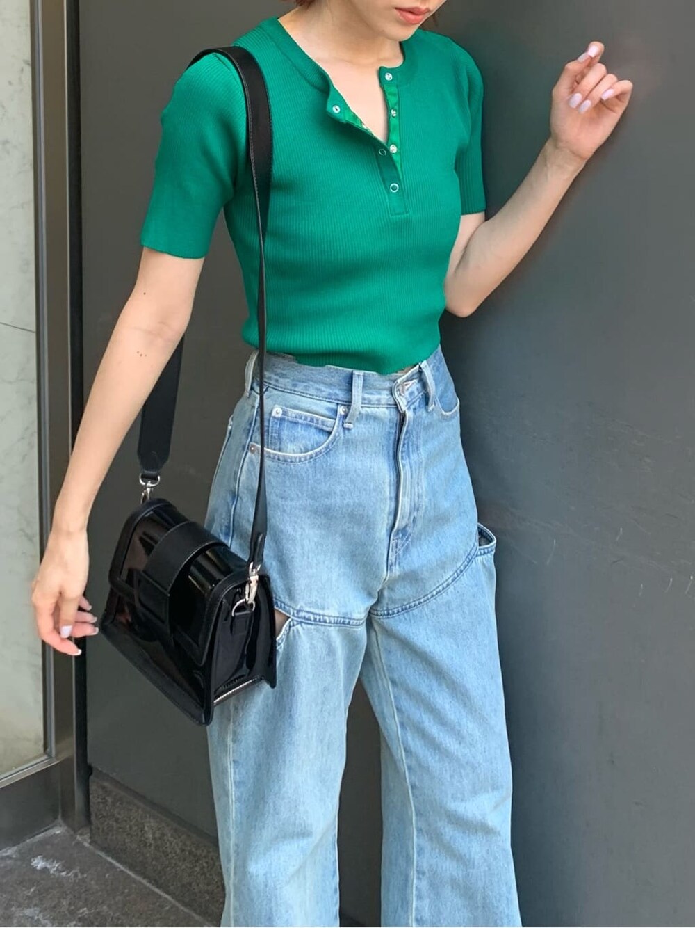 ブルー系のデニムパンツ、ブラック系のサンダル、ブラック系のショルダーバッグを着用したレディースの夏コーディネートの3枚目の写真