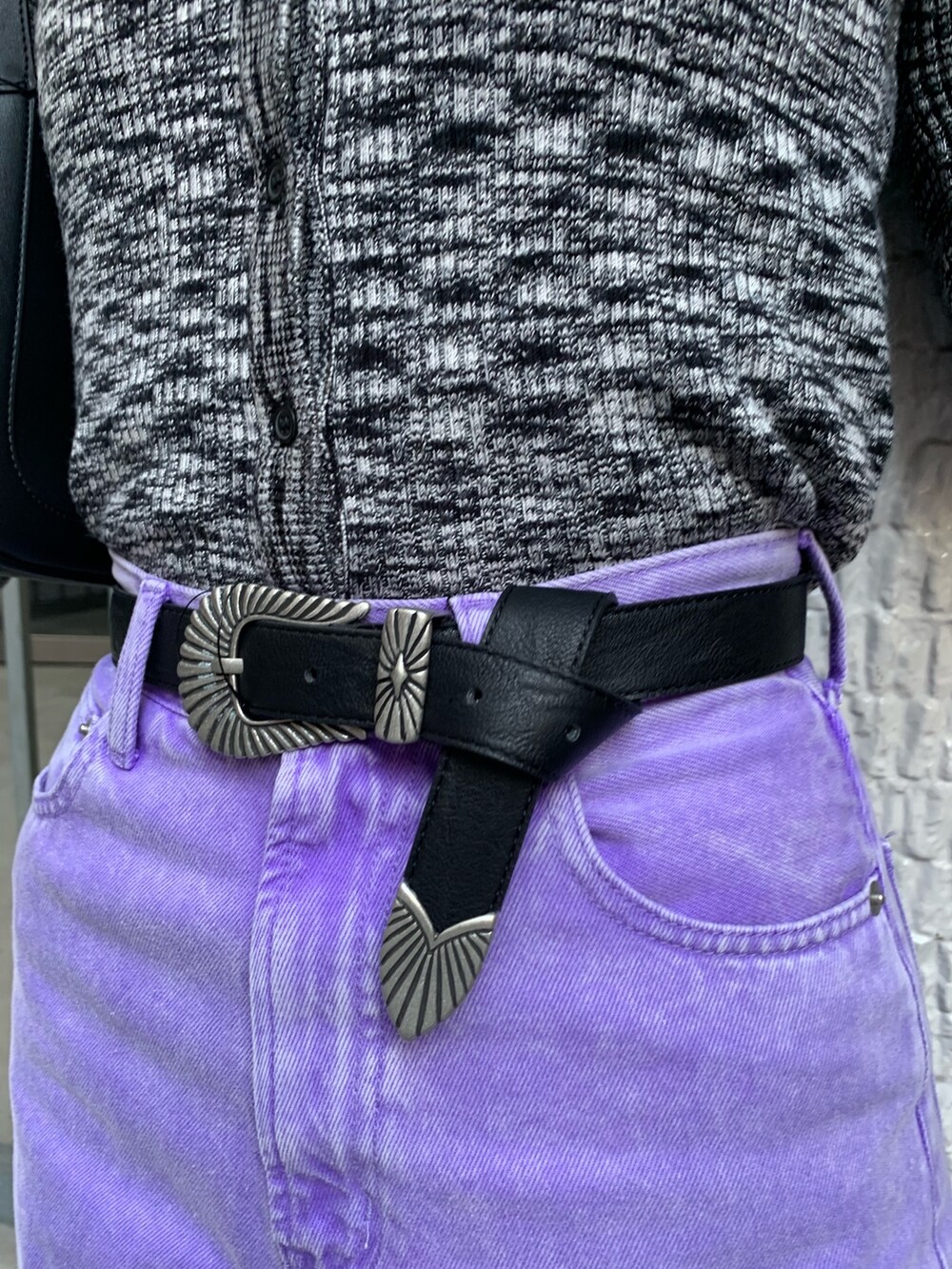 パープル系のデニムパンツ、ブラック系のニット/セーター、ブラック系のハンドバッグを着用したレディースの冬コーディネートの7枚目の写真