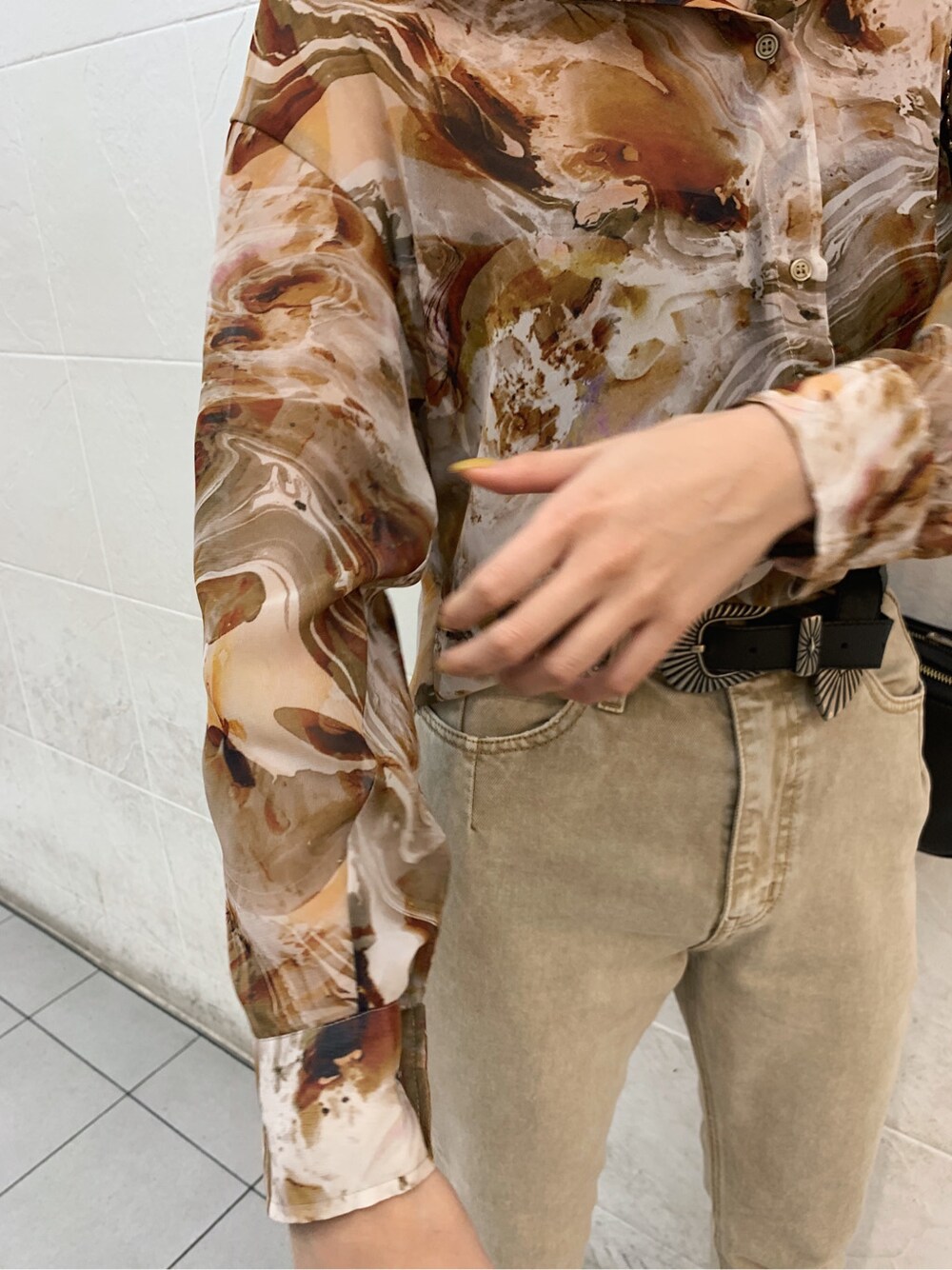 ブラウン系のキャミソール、ブラック系のサンダル、ベージュ系のデニムパンツを着用したレディースの春コーディネートの5枚目の写真