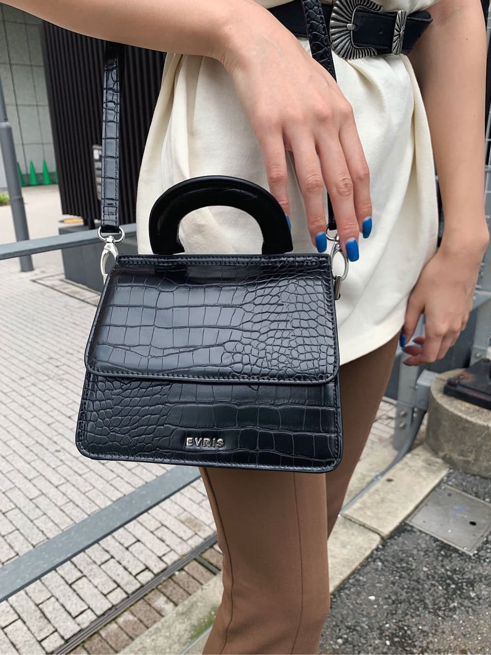 ブラック系のサンダル、ホワイト系のTシャツ/カットソー、ブラック系のベルトを着用したレディースの夏コーディネートの7枚目の写真