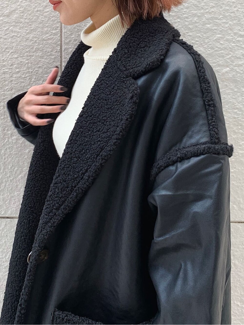 ブラック系のデニムパンツ、ブラック系のショルダーバッグ、ブラック系のブーツを着用したレディースの冬コーディネートの4枚目の写真