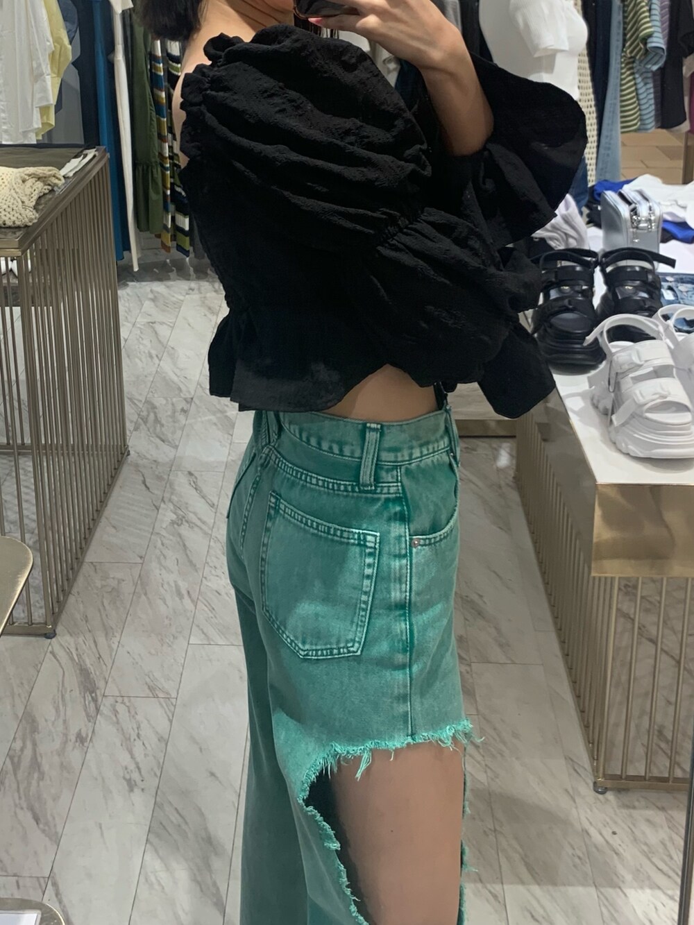 グリーン系のデニムパンツ、ブラック系のサンダル、ブラック系のシャツ/ブラウスを着用したレディースの春コーディネートの4枚目の写真