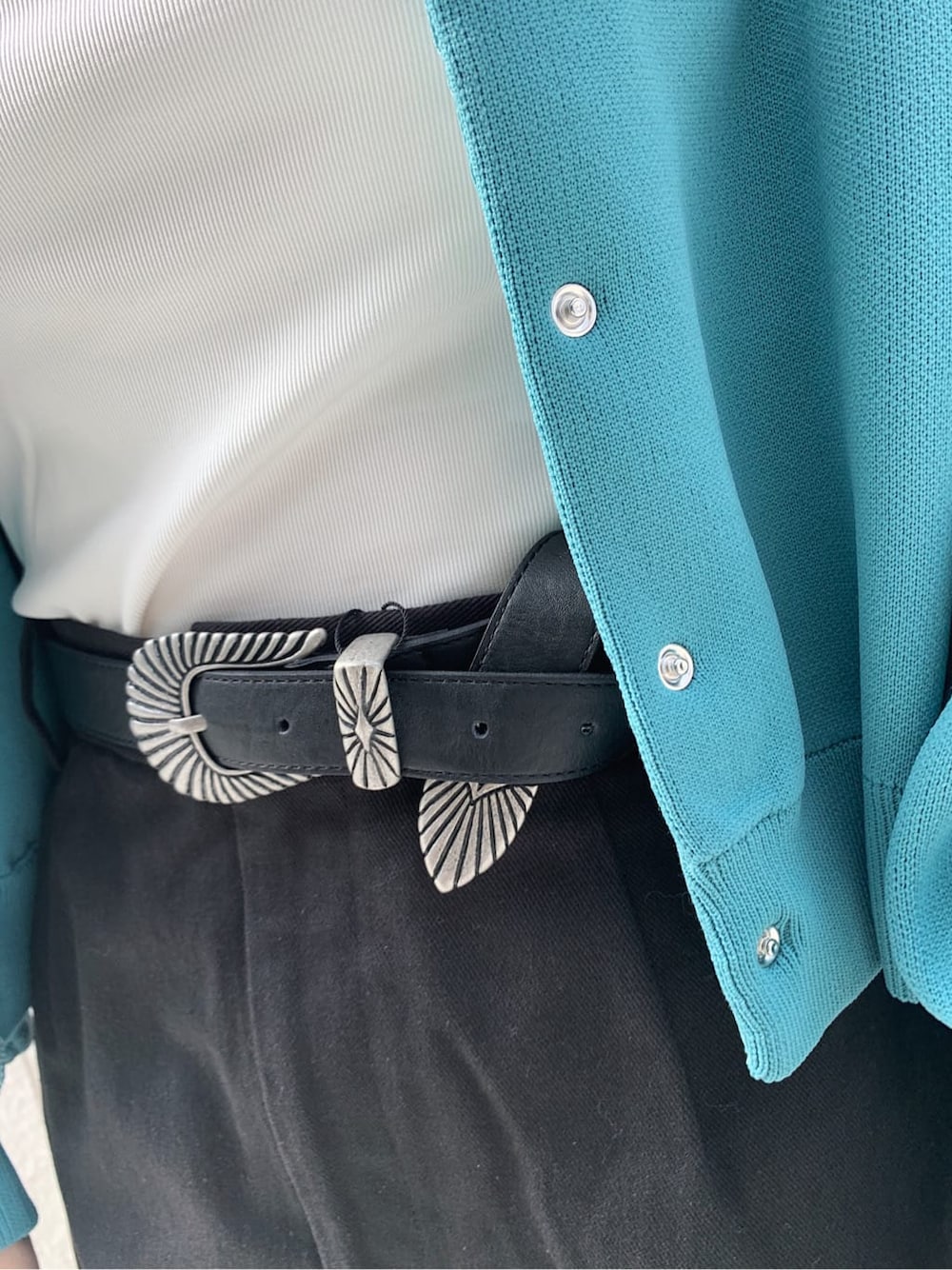 ブラック系のブーツ、ブラック系のスカート、ホワイト系のキャミソールを着用したレディースの冬コーディネートの7枚目の写真