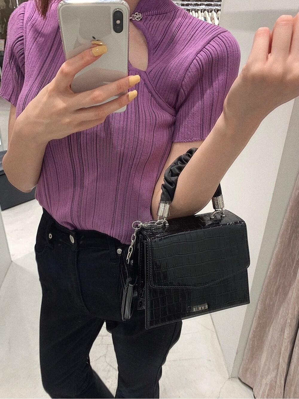 ブラック系のパンプス、ブラック系のデニムパンツ、パープル系のニット/セーターを着用したレディースの春コーディネートの5枚目の写真