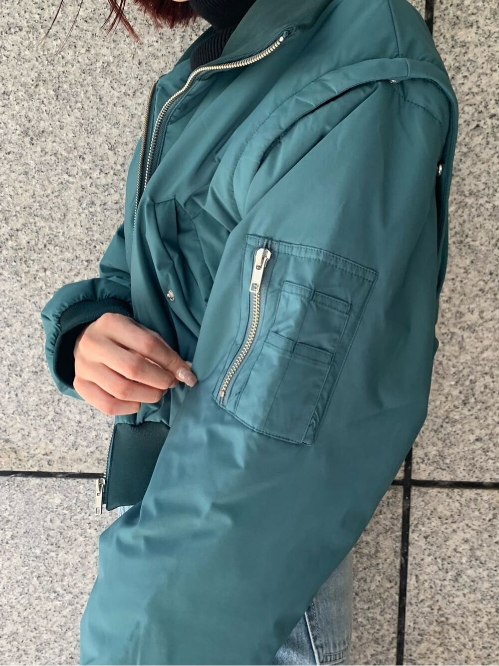 ブラック系のハンドバッグ、ブルー系のデニムパンツ、ブルー系のMA-1を着用したレディースの秋コーディネートの6枚目の写真