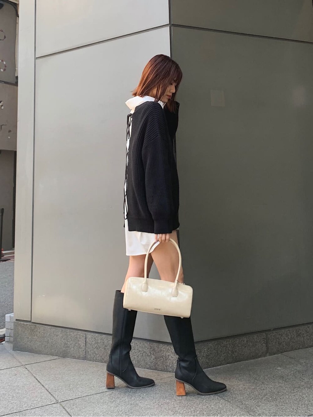 ブラック系のブーツ、ベージュ系のボストンバッグ、ホワイト系のシャツ/ブラウスを着用したレディースの冬コーディネートの3枚目の写真