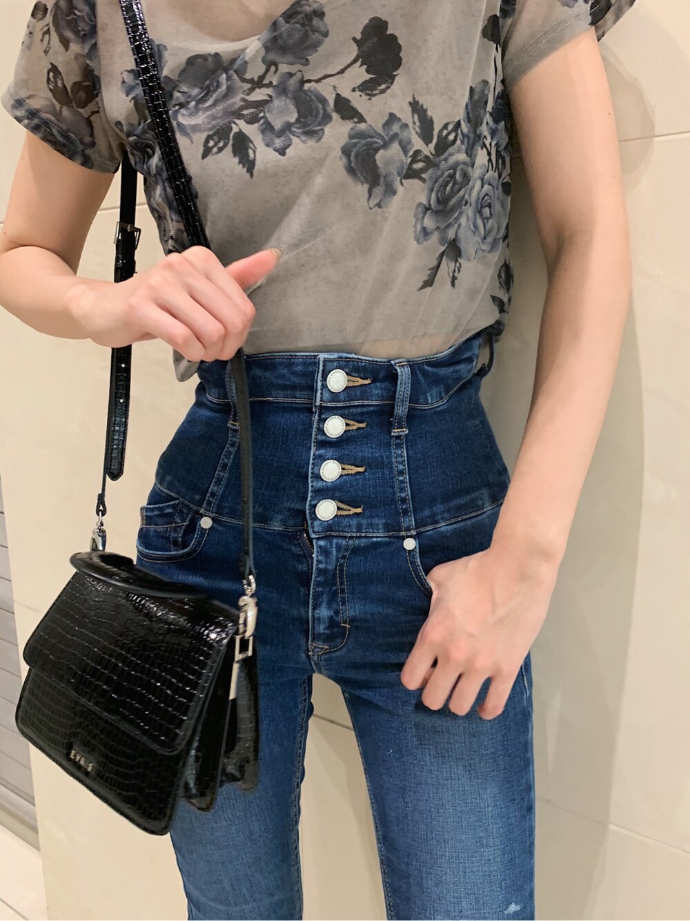 ブルー系のデニムパンツ、ブラック系のサンダルを着用したレディースの春コーディネートの3枚目の写真