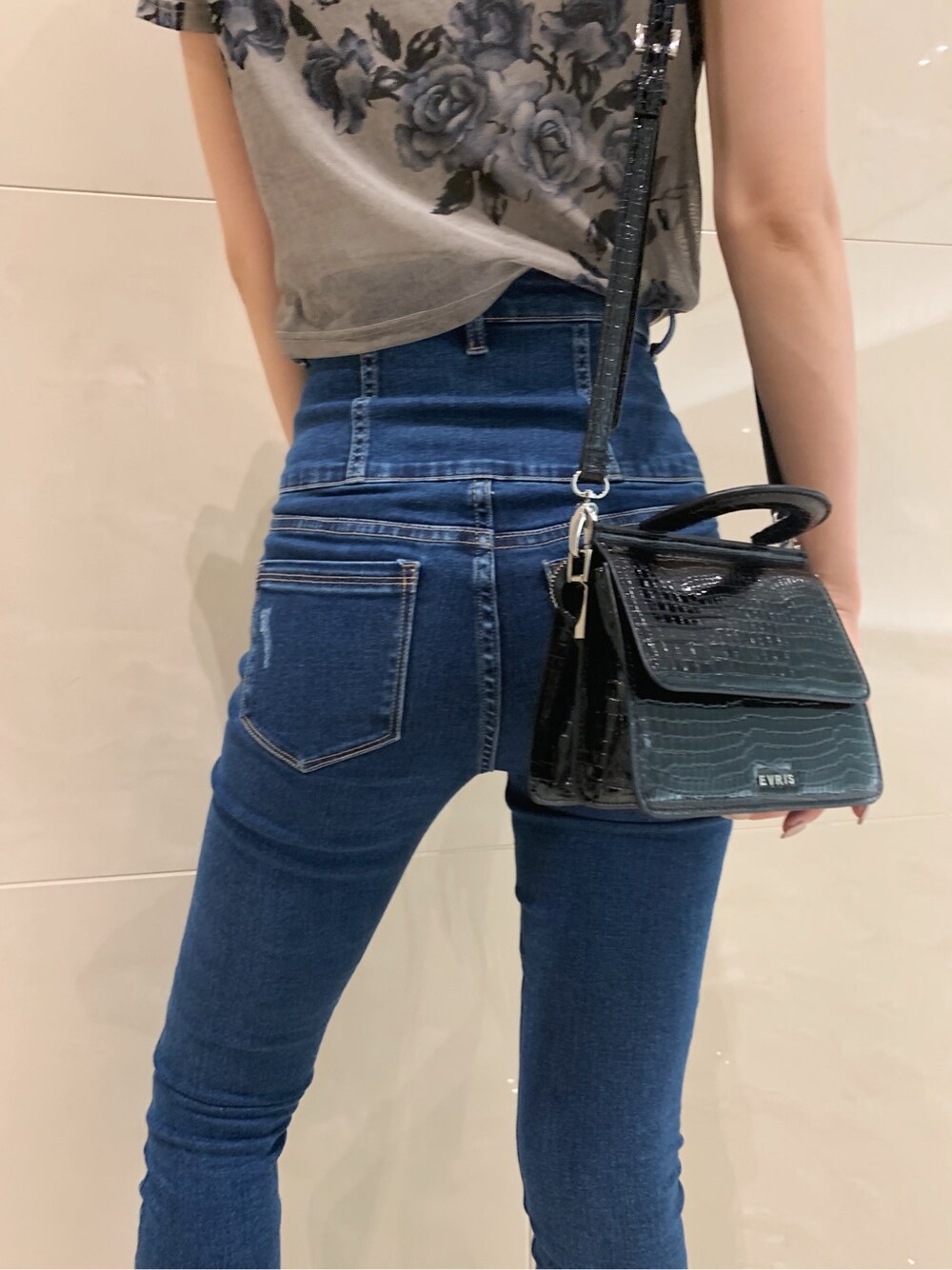 ブルー系のデニムパンツ、ブラック系のサンダルを着用したレディースの春コーディネートの4枚目の写真