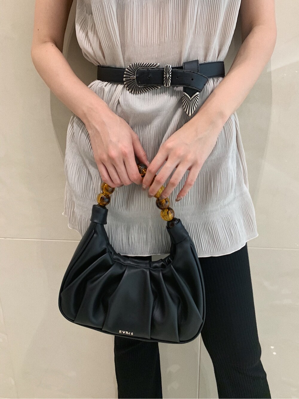 ホワイト系のTシャツ/カットソー、ブラック系のその他パンツ、ブラック系のハンドバッグを着用したレディースの春コーディネートの7枚目の写真