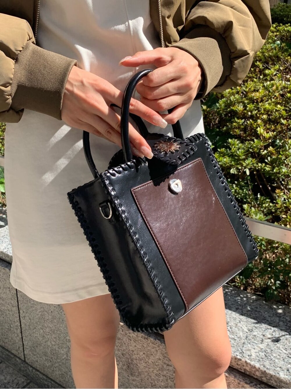 ブラック系のショルダーバッグ、グリーン系のMA-1、ホワイト系のワンピースを着用したレディースの秋コーディネートの9枚目の写真