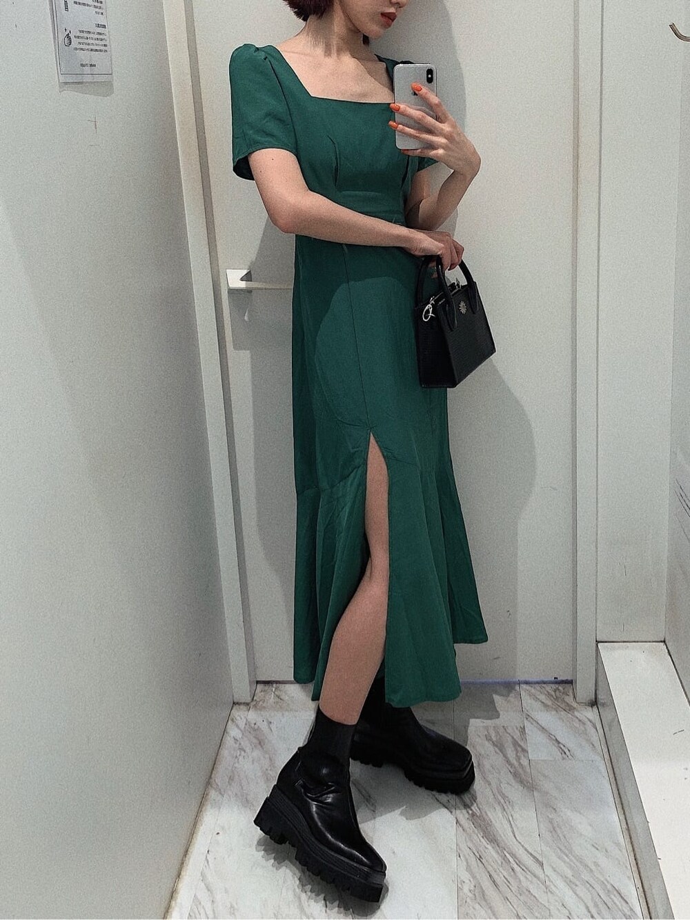 ブラック系のブーツ、ブラック系のショルダーバッグ、グリーン系のワンピースを着用したレディースの春コーディネートの2枚目の写真