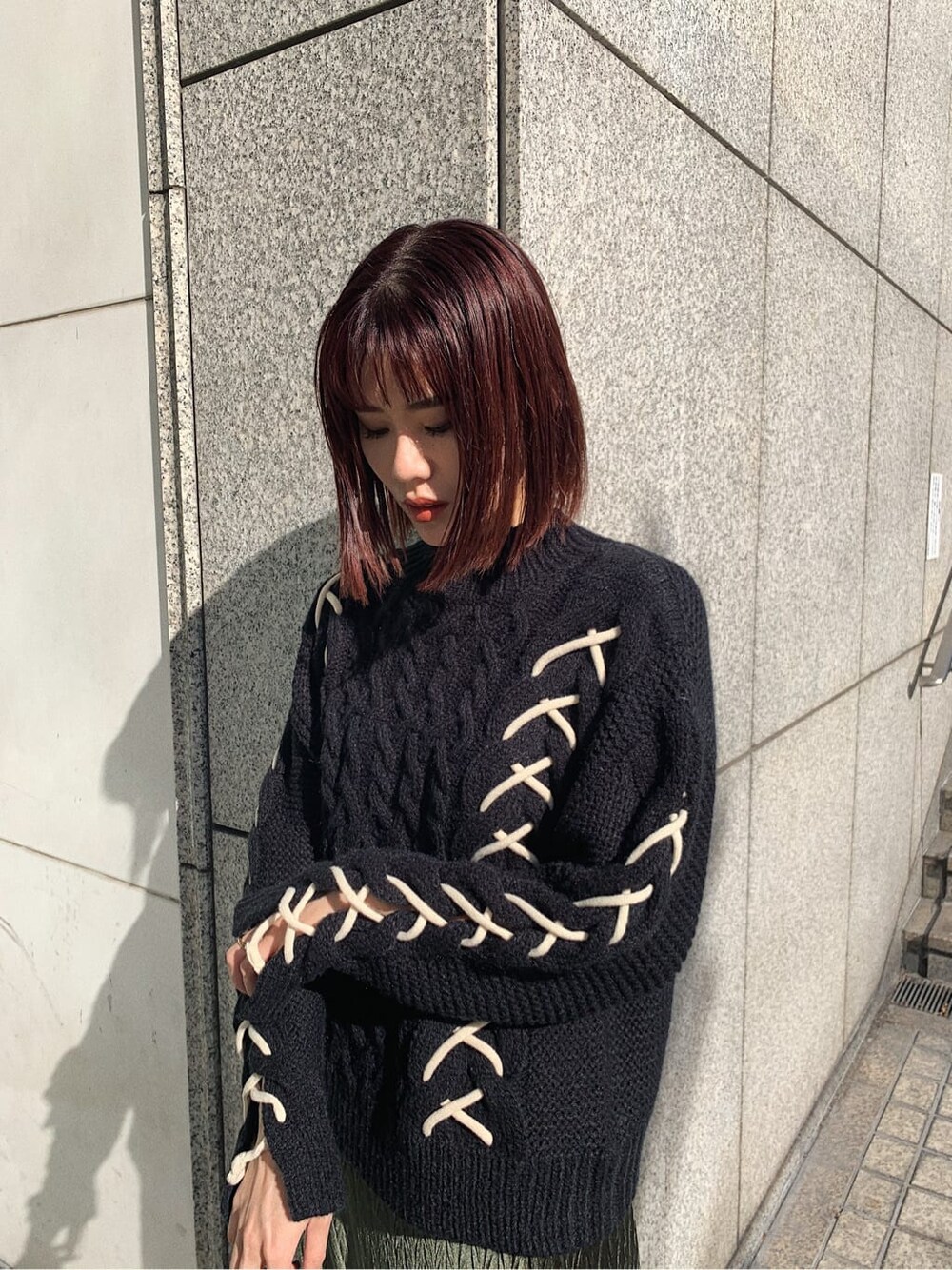 ブラック系のニット/セーター、ブラック系のショルダーバッグ、ベージュ系のワンピースを着用したレディースの冬コーディネートの3枚目の写真