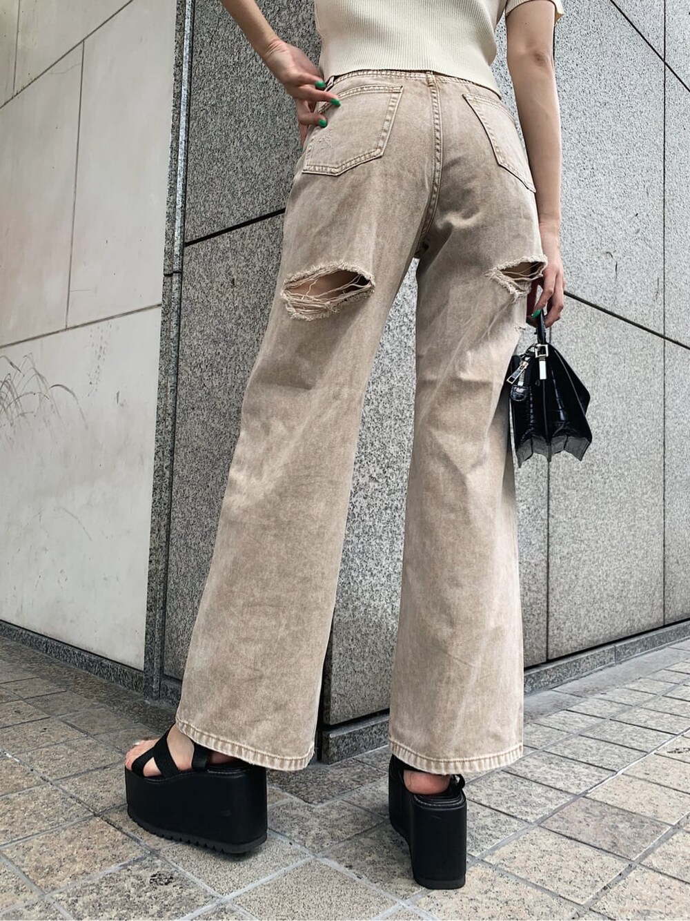 ブラック系のサンダル、ベージュ系のデニムパンツ、ホワイト系のニット/セーターを着用したレディースの夏コーディネートの5枚目の写真