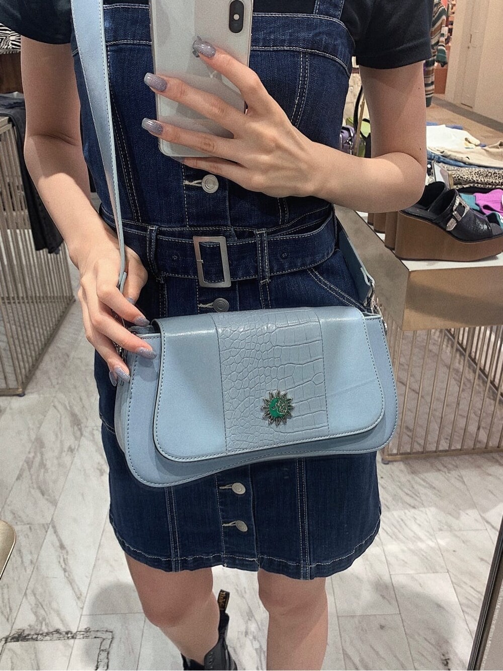 ブラック系のブーツ、ブラック系のTシャツ/カットソー、ブルー系のジャンパースカートを着用したレディースの春コーディネートの6枚目の写真