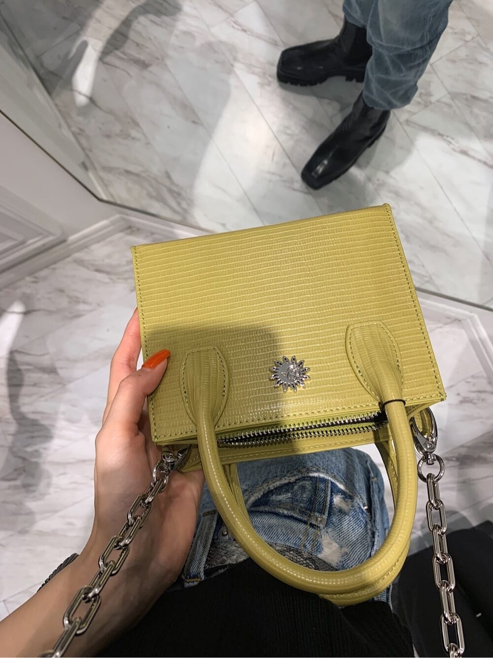 ブラック系のブーツ、ブラック系のニット/セーター、イエロー系のショルダーバッグを着用したレディースの春コーディネートの5枚目の写真